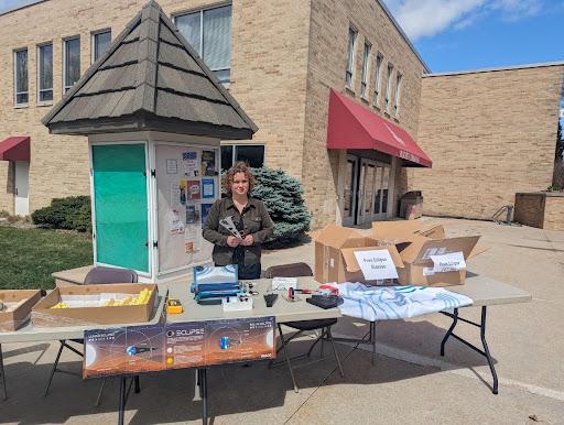 Professor Othon stands at the table outside of the commons, ready to hand out eclipse glasses to students. Photo Courtesy of Caitlin Marsch.