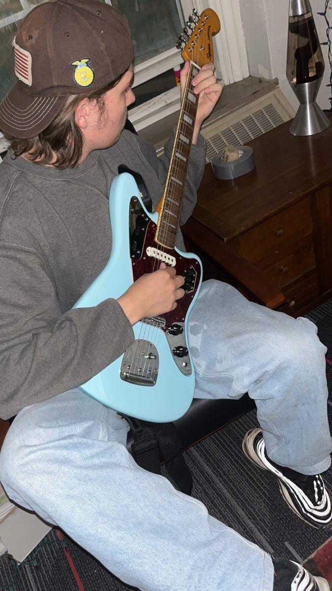 First-year student Tyler Hebein plays his guitar in his dorm. Photo Courtesy of Eduardo Zermeno.
